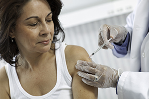 Woman getting immunization in upper arm.